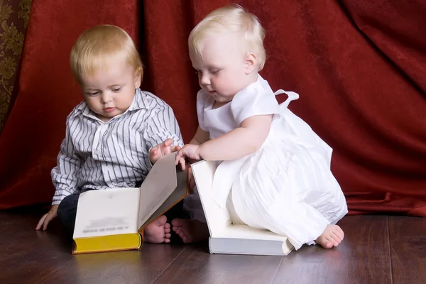 Děti číst knihy, sedí na podlaze proti — Stock fotografie