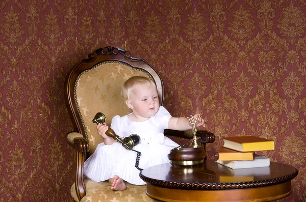 Chica con el teléfono en la mano sentado en una silla vieja —  Fotos de Stock