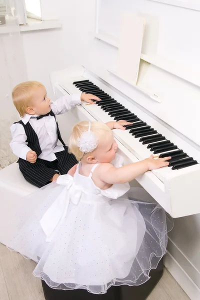少年と少女白いピアノを再生 — ストック写真
