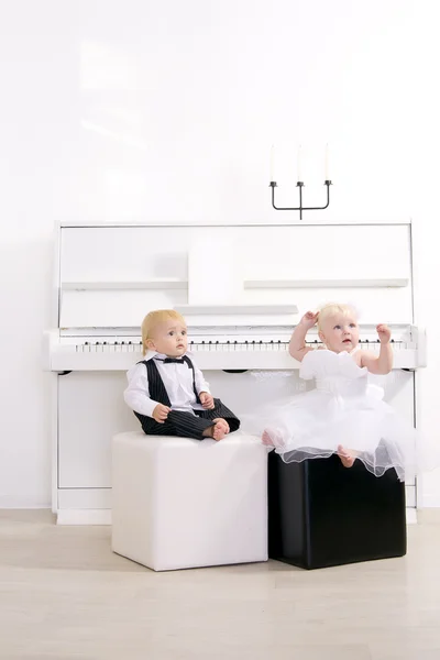 Chlapec a dívka v šatech sedící v interiéru koncert — Stock fotografie