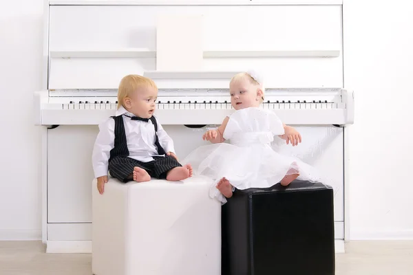 Menino e menina em um terno sentado em um interior de concerto — Fotografia de Stock