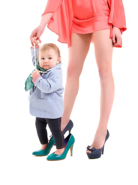 어머니는 작은 딸의 손을 잡고, 둘 다 유행 옷을 입고 하 고 발뒤꿈치와 신발 입고 — 스톡 사진