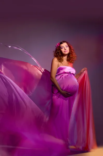 Donna incinta in tessuto rosa volante — Foto Stock