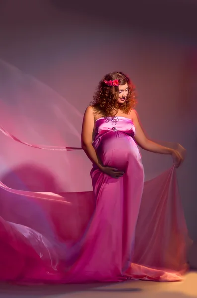 Pregnant woman in a pink fabric flying — Stock Photo, Image