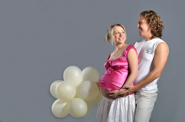 Moda jovem casal esperando um bebê, fundo cinza com whit — Fotografia de Stock