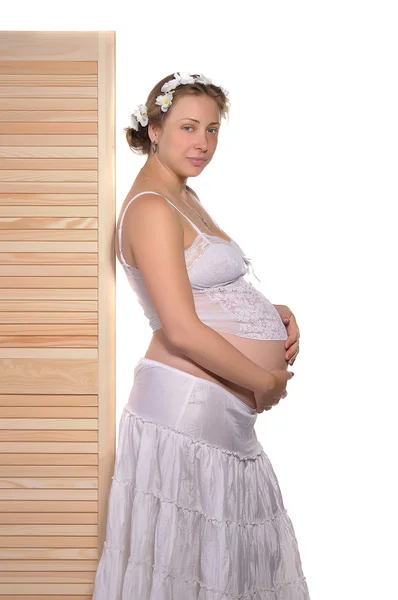 Vackra gravid kvinna står nära ett trästaket — Stockfoto