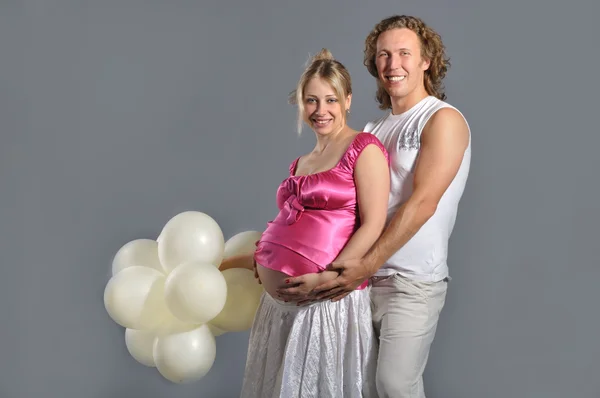 Moda jovem casal esperando um bebê, fundo cinza com whit — Fotografia de Stock