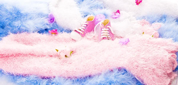 Dans des revêtements à fourrure multicolores sont des fleurs et des chaussures de bébé — Photo