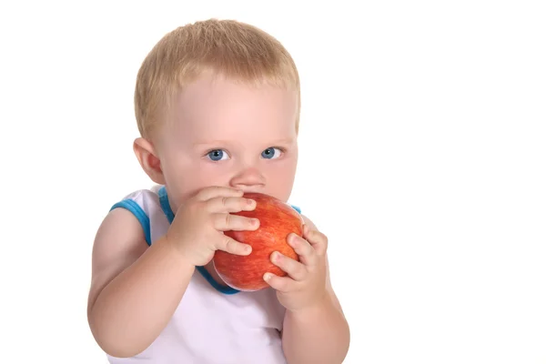 Child, a boy, he eats an apple, holding it with both hands — Stock Photo, Image