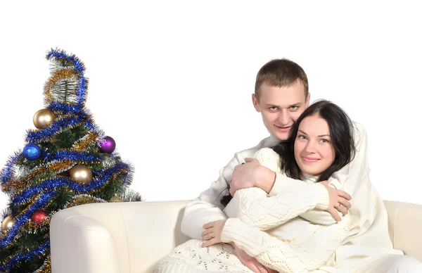Casal sentado em um sofá perto da árvore de Natal — Fotografia de Stock