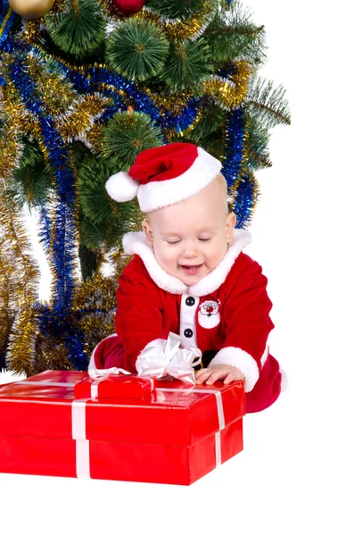 Little baby boy wearing Santa's costume sitting and holding a box with — Stock Photo, Image
