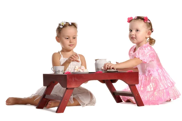 Pretty twins sisters have tea with zephyr isolated on white bac — Stock Photo, Image