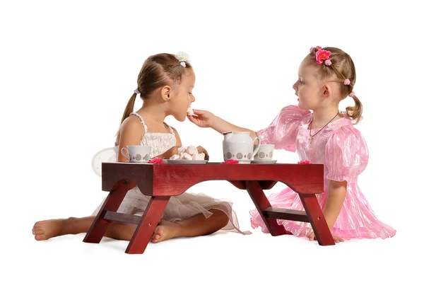 漂亮双胞胎姐妹喝茶与西风上白色 bac 隔离 — 图库照片