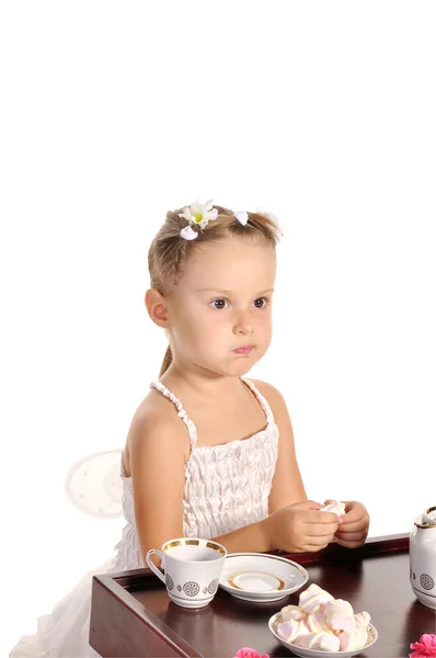 Милая маленькая девочка пьет чай с зефиром изолирован на белом backgr — стоковое фото