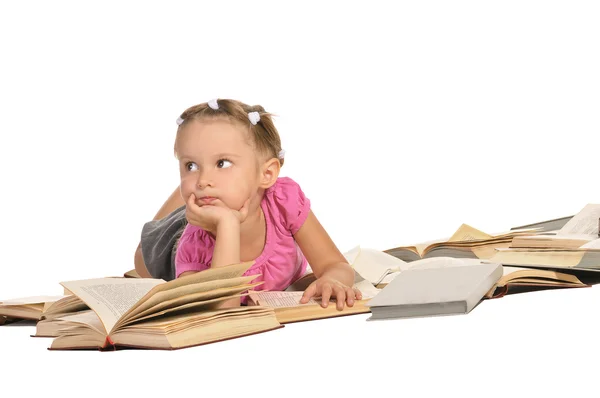 Милая маленькая девочка лежит на куче книг изолированных на белом backgr — стоковое фото
