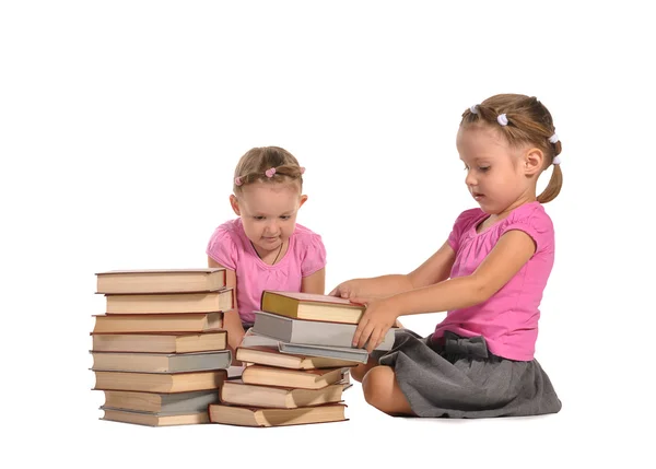 Pretty twins girls with pile of books isolated on white backgrou — Stock Photo, Image