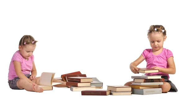 Bliźnięta ładne dziewczyny z stos książek na białym tle na biały backgrou — Zdjęcie stockowe