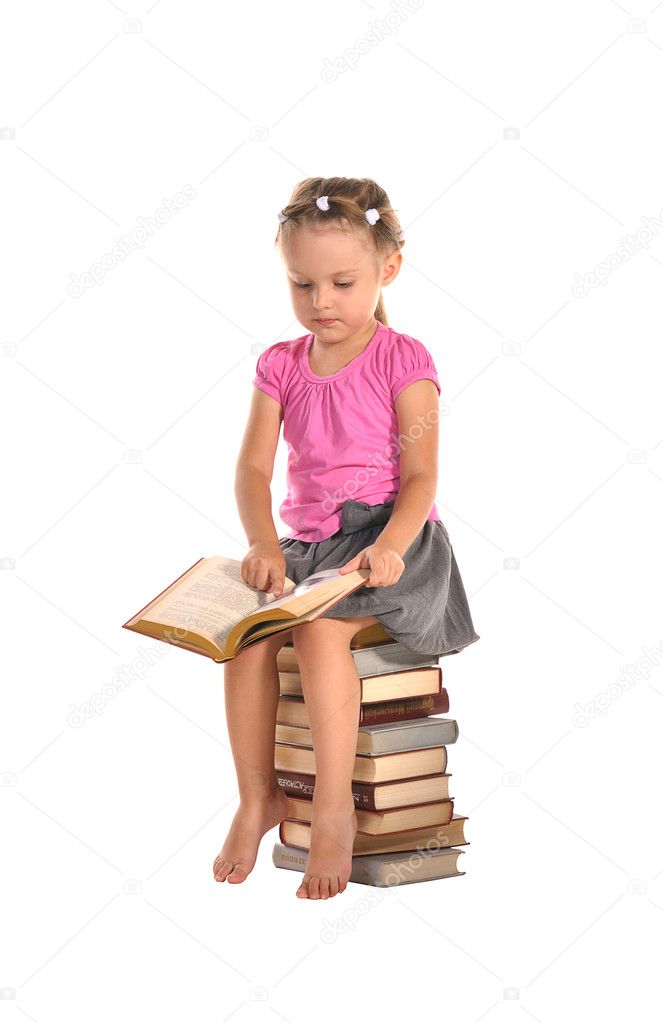 Nice little girl sitting on stack of books isolated on white bac
