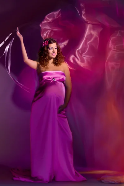 Mooie zwangere vrouw in roze en paarse jurk 1 — Stockfoto