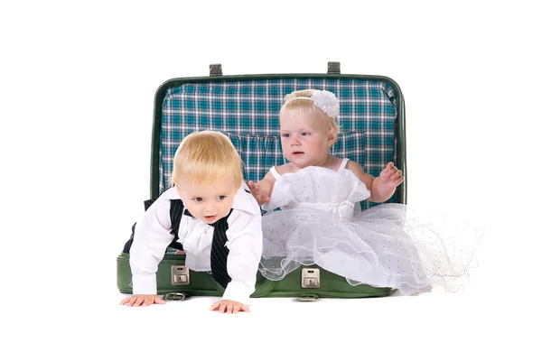 Ragazzo e una ragazza seduti in una valigia, che vanno a viaggiare — Foto Stock