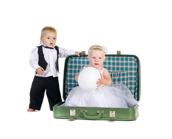 Boy and a girl sitting in a suitcase, going to travel — Stock Photo, Image