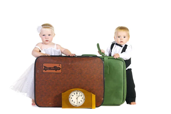 A boy and a girl dressed as newlyweds stand near luggage — Stock Photo, Image