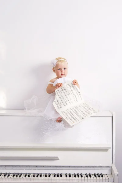 Girl on a white piano — Stock Photo, Image