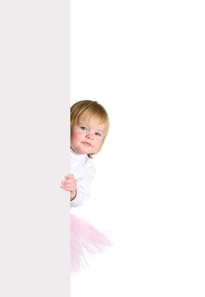 Menina em bailarinas tutu olha para fora do billboa em branco — Fotografia de Stock
