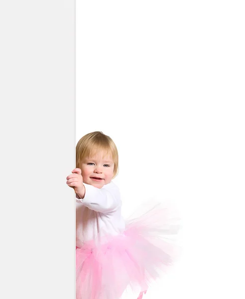 Little girl in ballerinas tutu look outs from the blank billboa — Stock Photo, Image