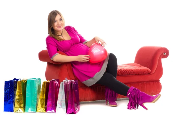 Těhotné ženy v šatech růžové barvy, s nákupní tašky — Stock fotografie