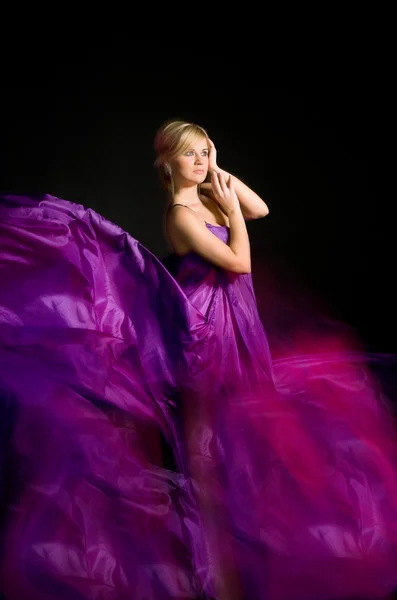 Beautiful blonde in a dress made of fabric flying — Stock Photo, Image