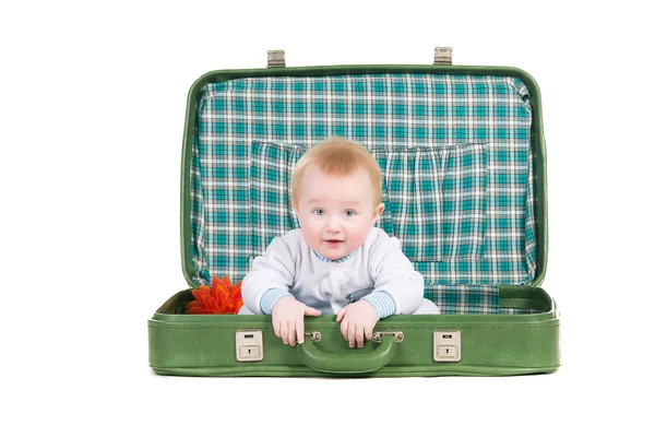 赤ちゃんの traveli を見越して古い緑スーツケースに座っています。 — ストック写真