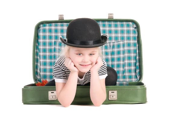 Ребенок сидит в старом зеленом чемодане в ожидании поездки — стоковое фото