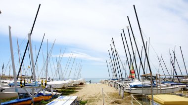 Sailboats staked in Sitges's beach clipart
