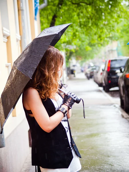 Κορίτσι με ομπρέλα στη βροχή είναι στο δρόμο — Φωτογραφία Αρχείου