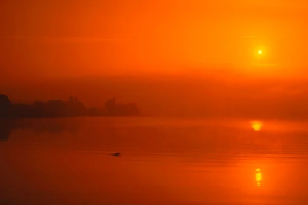 Nascer do sol acima do lago com uma névoa — Fotografia de Stock