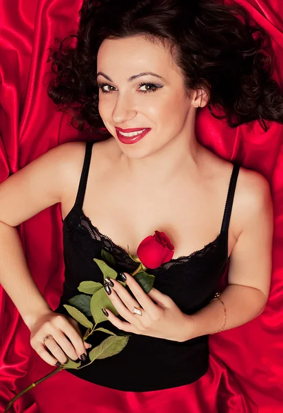De mooie vrouw met een roos — Stockfoto