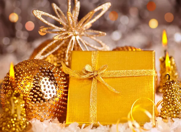 Χρυσή δώρο Χριστουγέννων με διακοσμήσεις φανταχτερά και άχρηστα στολίδια και κεριά — Φωτογραφία Αρχείου