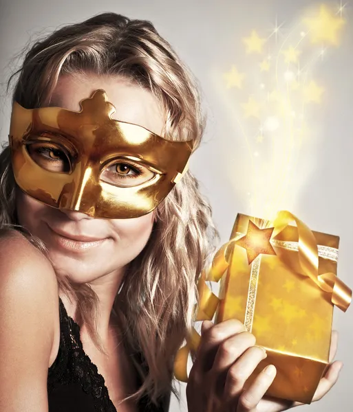 Stylish woman with golden mask and gift — Stock Photo, Image