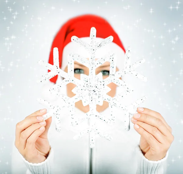 Sneeuwvlok in santa meisje handen — Stockfoto