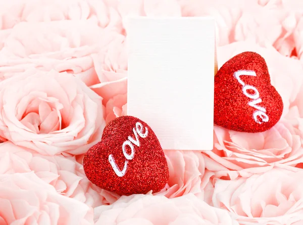Rosas cor-de-rosa bonitas com cartão de presente e corações — Fotografia de Stock