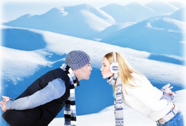 Happy couple playing outdoor at winter mountains clipart