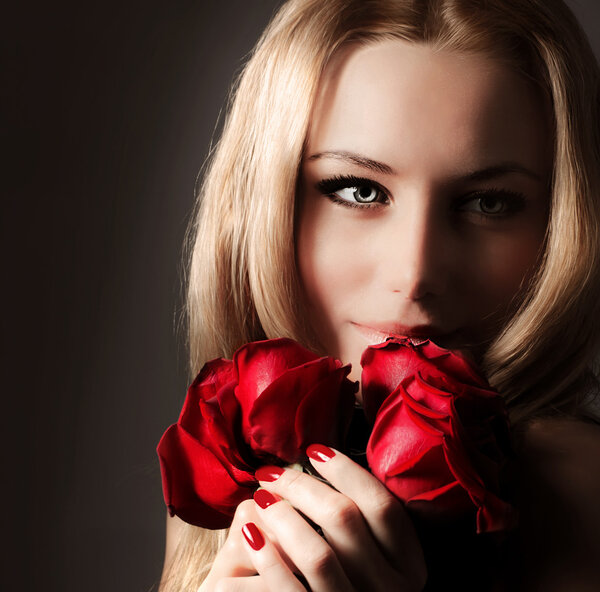Stylish beautiful young woman holding red roses bouquet, tender flowers in hands, blond female over dark background, gorgeous girl with fresh plant, lady in lov