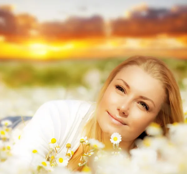 Hermosa mujer disfrutando del campo de flores al atardecer — Foto de Stock