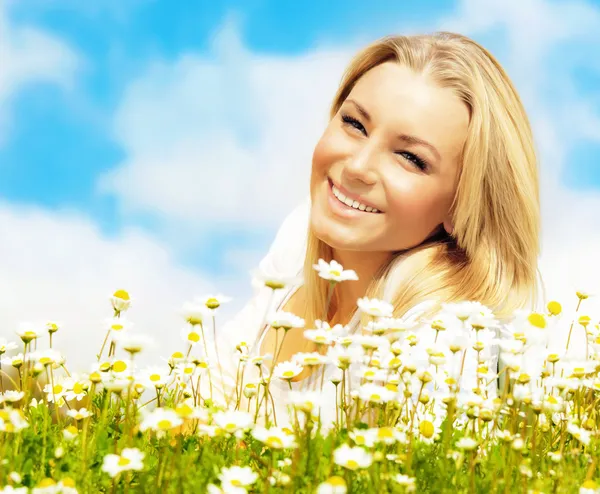 Hermosa mujer disfrutando del campo de margaritas y el cielo azul — Foto de Stock