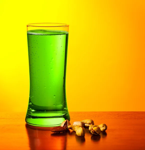 Green beer and nuts — Stock Photo, Image