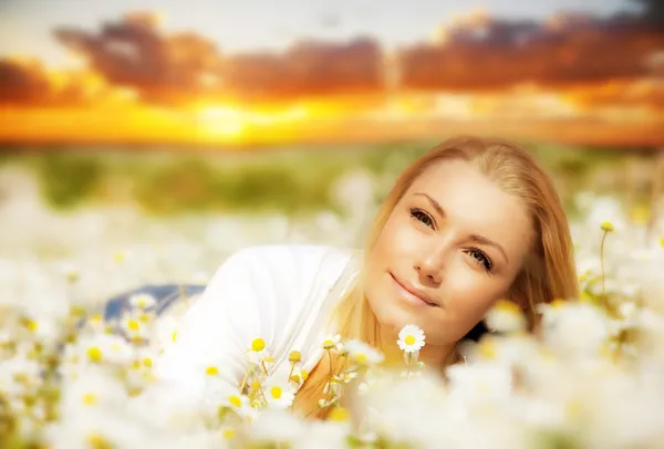 Hermosa mujer disfrutando del campo de flores al atardecer —  Fotos de Stock