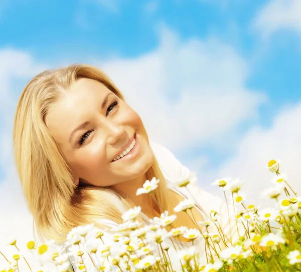 Schöne Frau genießt Gänseblümchenfeld und blauen Himmel — Stockfoto