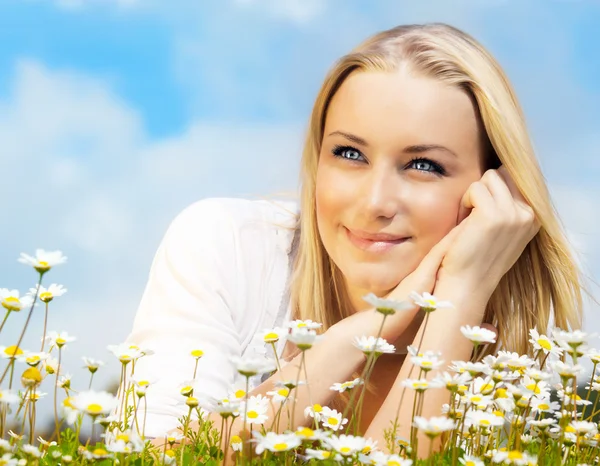 Hermosa mujer disfrutando del campo de margaritas y el cielo azul —  Fotos de Stock