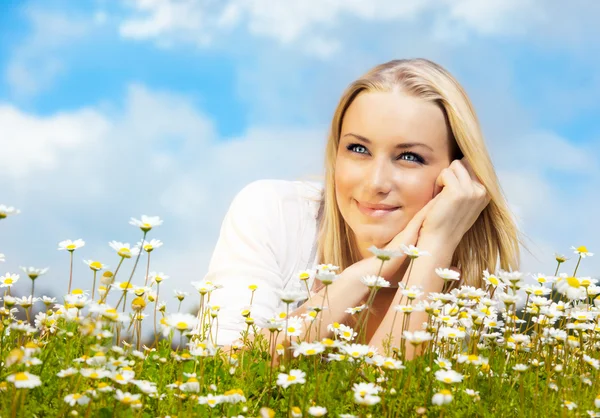 Schöne Frau genießt Gänseblümchenfeld und blauen Himmel — Stockfoto